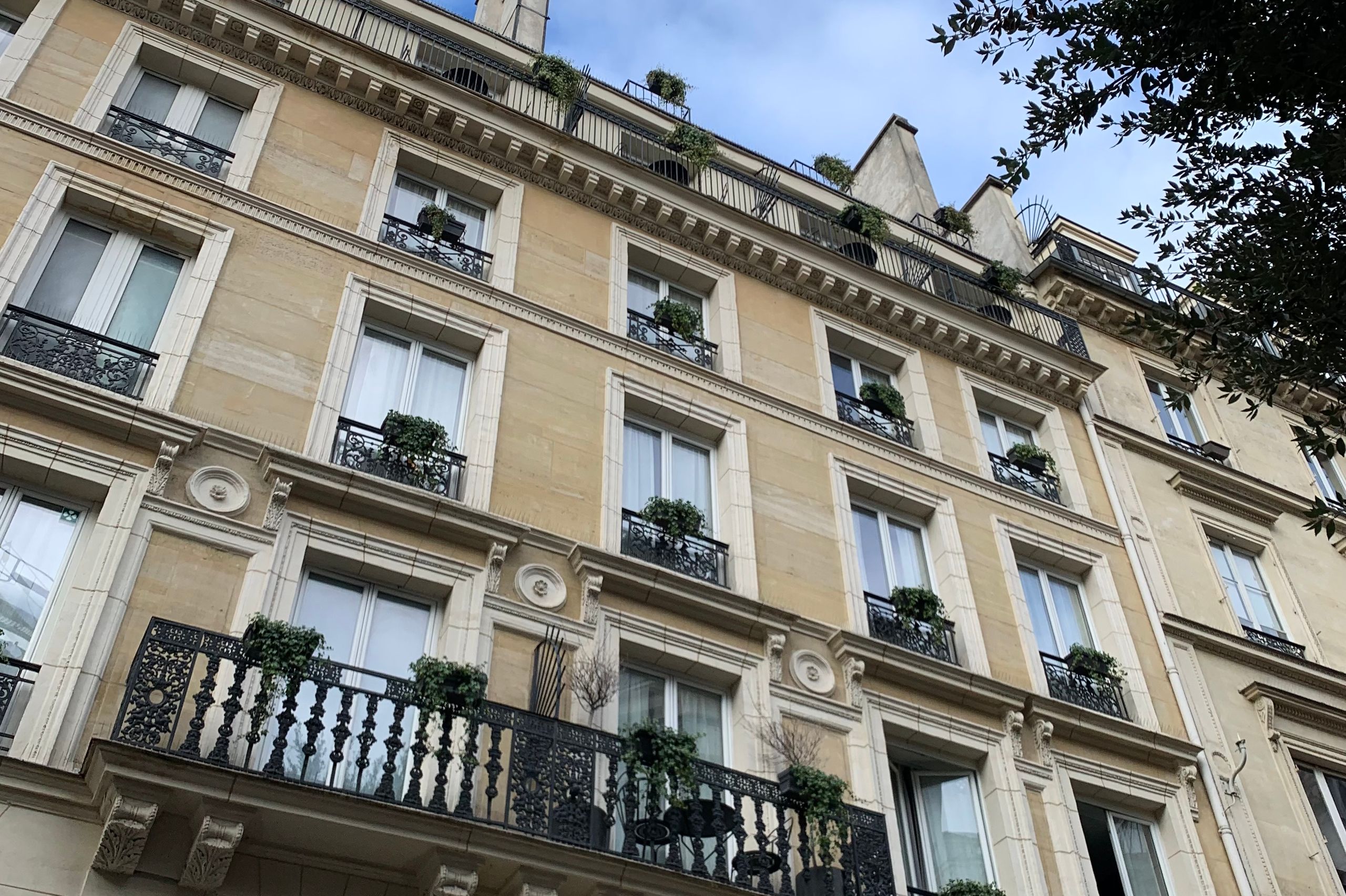 Façade d’un immeuble parisien classique avec balcons en fer forgé