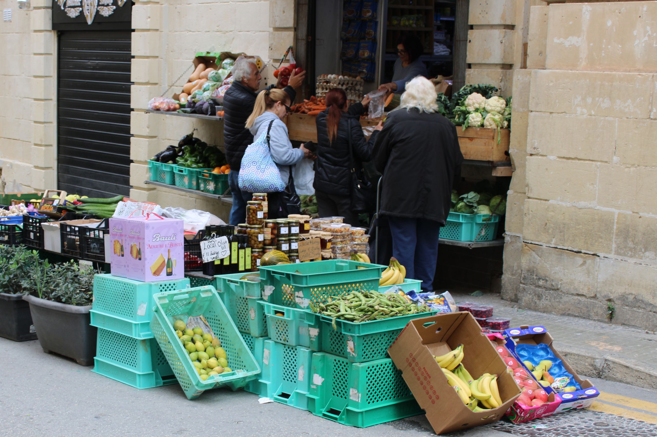 Clients faisant leurs courses devant les étals d’un marché de rue à Paris